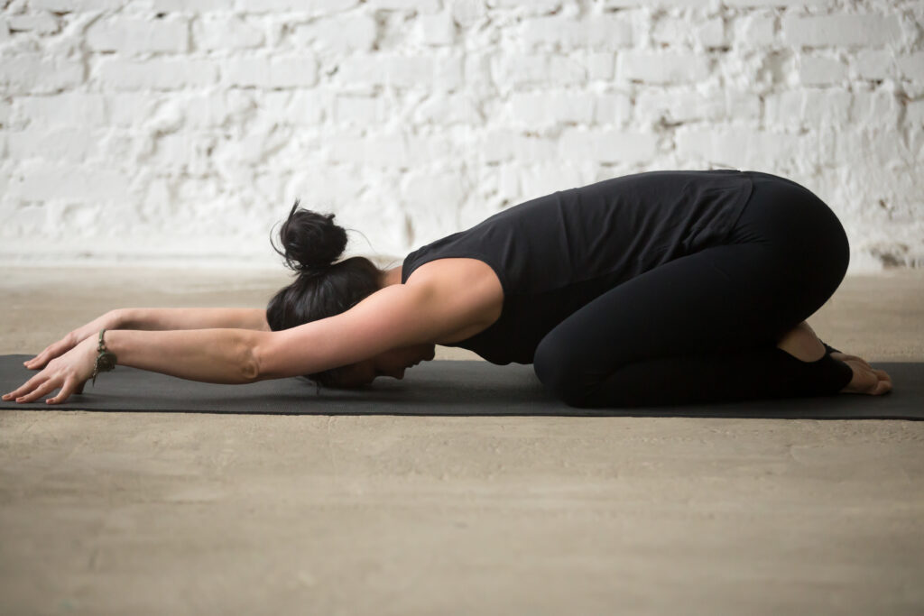 Young yogi attractive woman in Child pose,